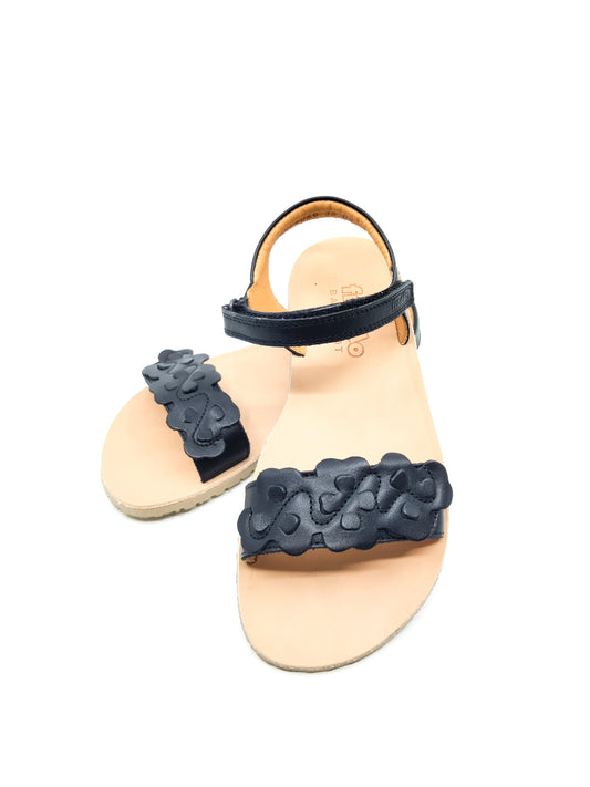 Mustat nahkaiset remmi sandaalit missä nahkaan leikattu kukanmallisia kuvioita 